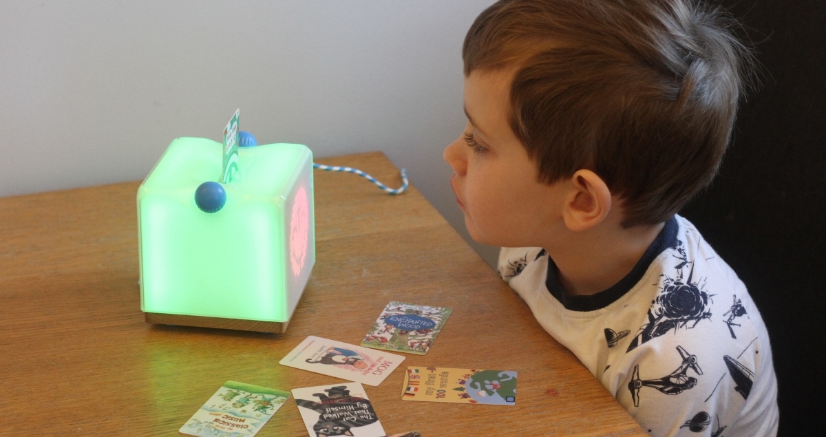 A boy using the light-up Yoto Clever Speaker