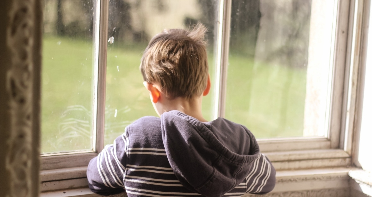 Boy looking out of a window at NT Croome